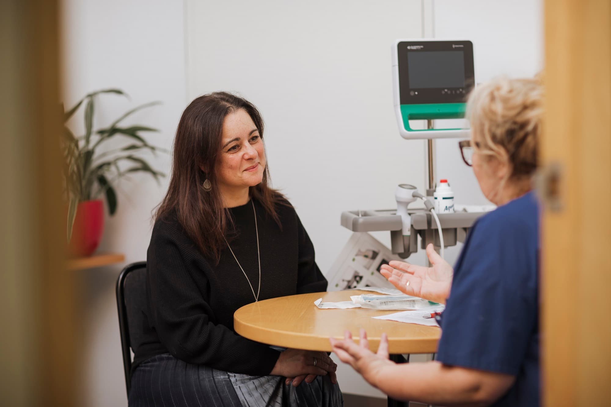 A client of MS Plus speaking with an MS Plus Allied Health worker in a consultation room.