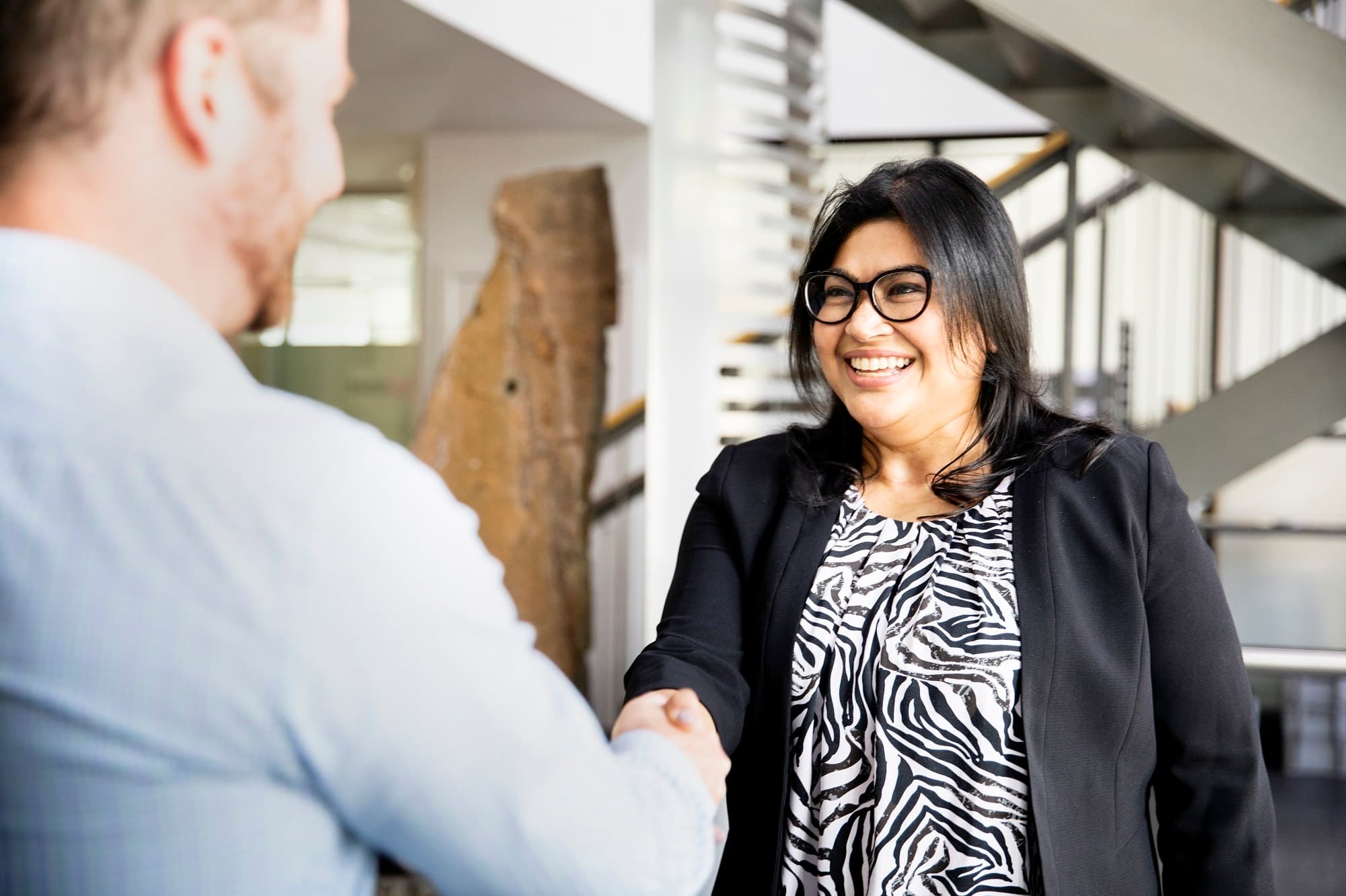 A businesswoman shaking hands with a man.