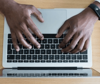 Hands on a laptop keyboard