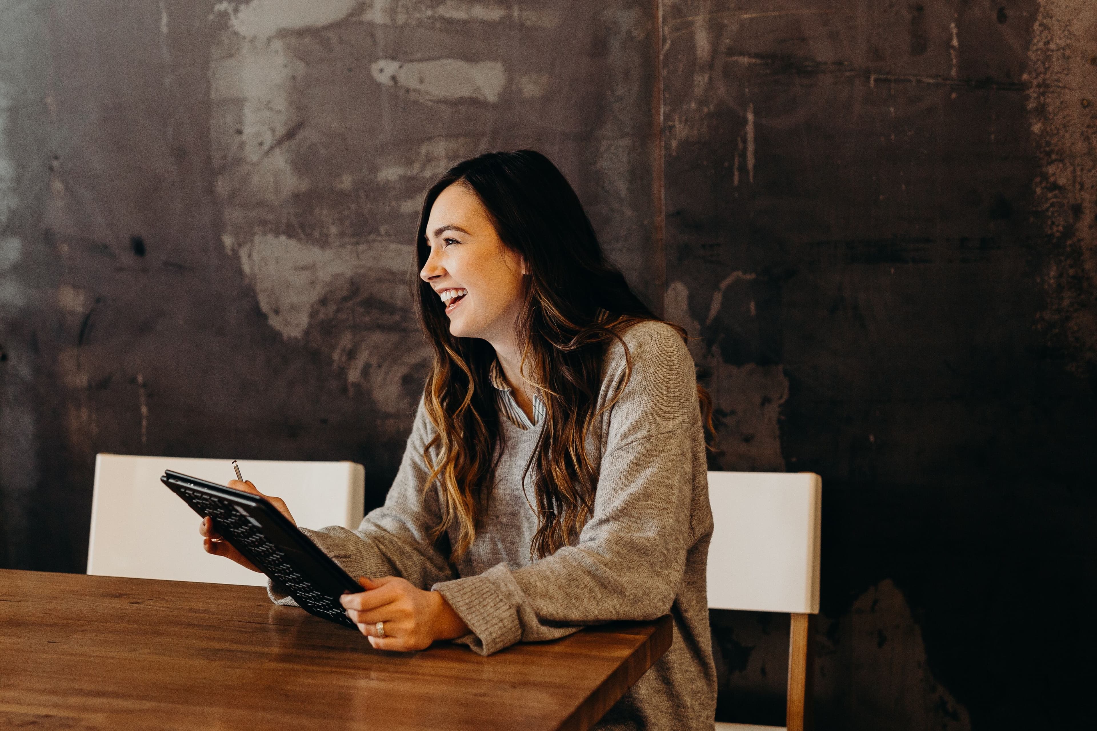 woman laughing at a laptop
