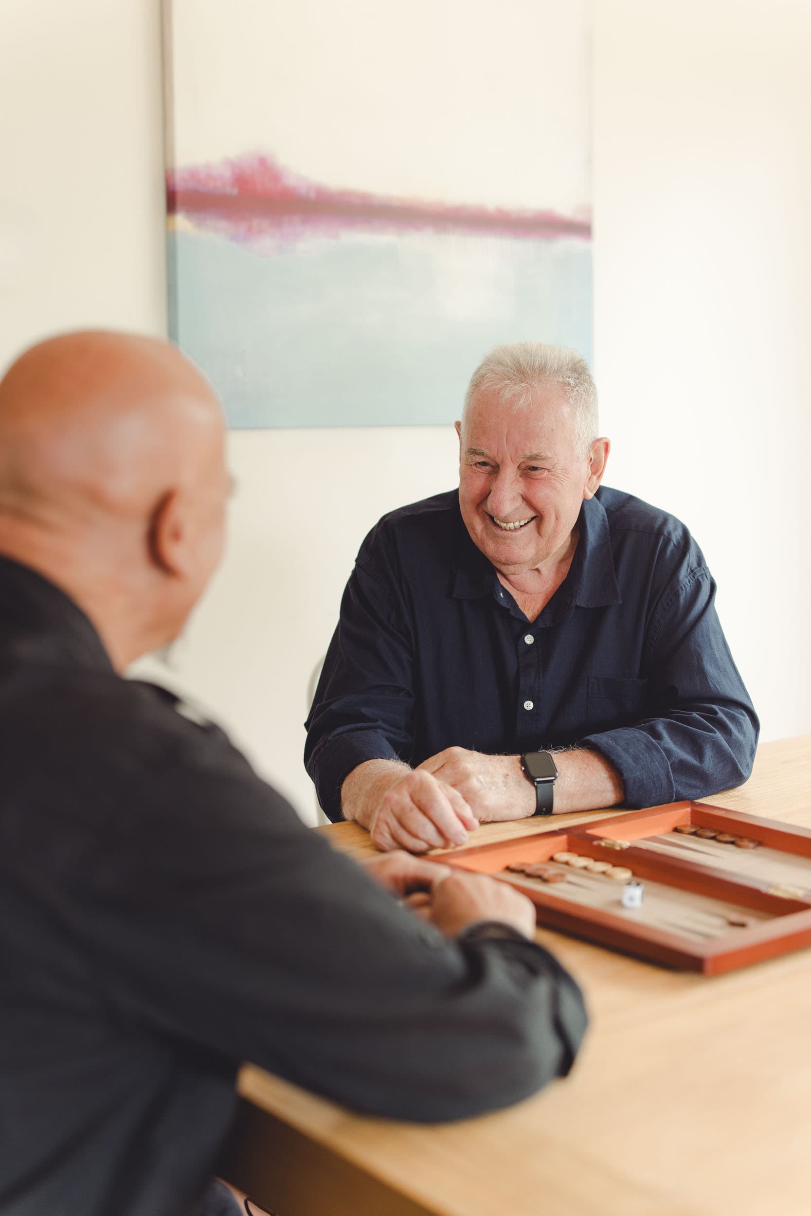 Man playing checkers with a volunteer