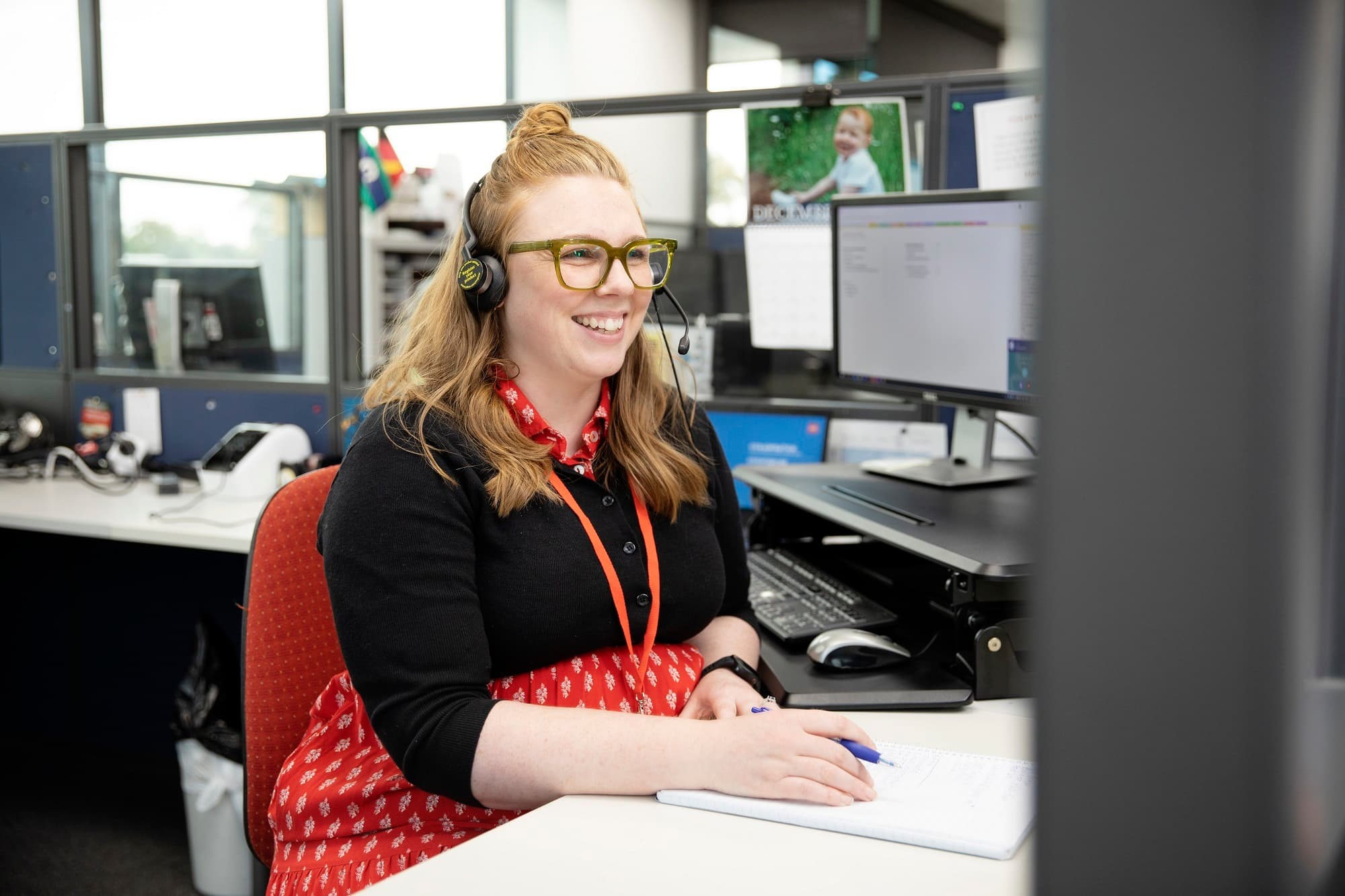 An MS Plus Connect staff member seated at her desk on the phone with an MS Plus client.