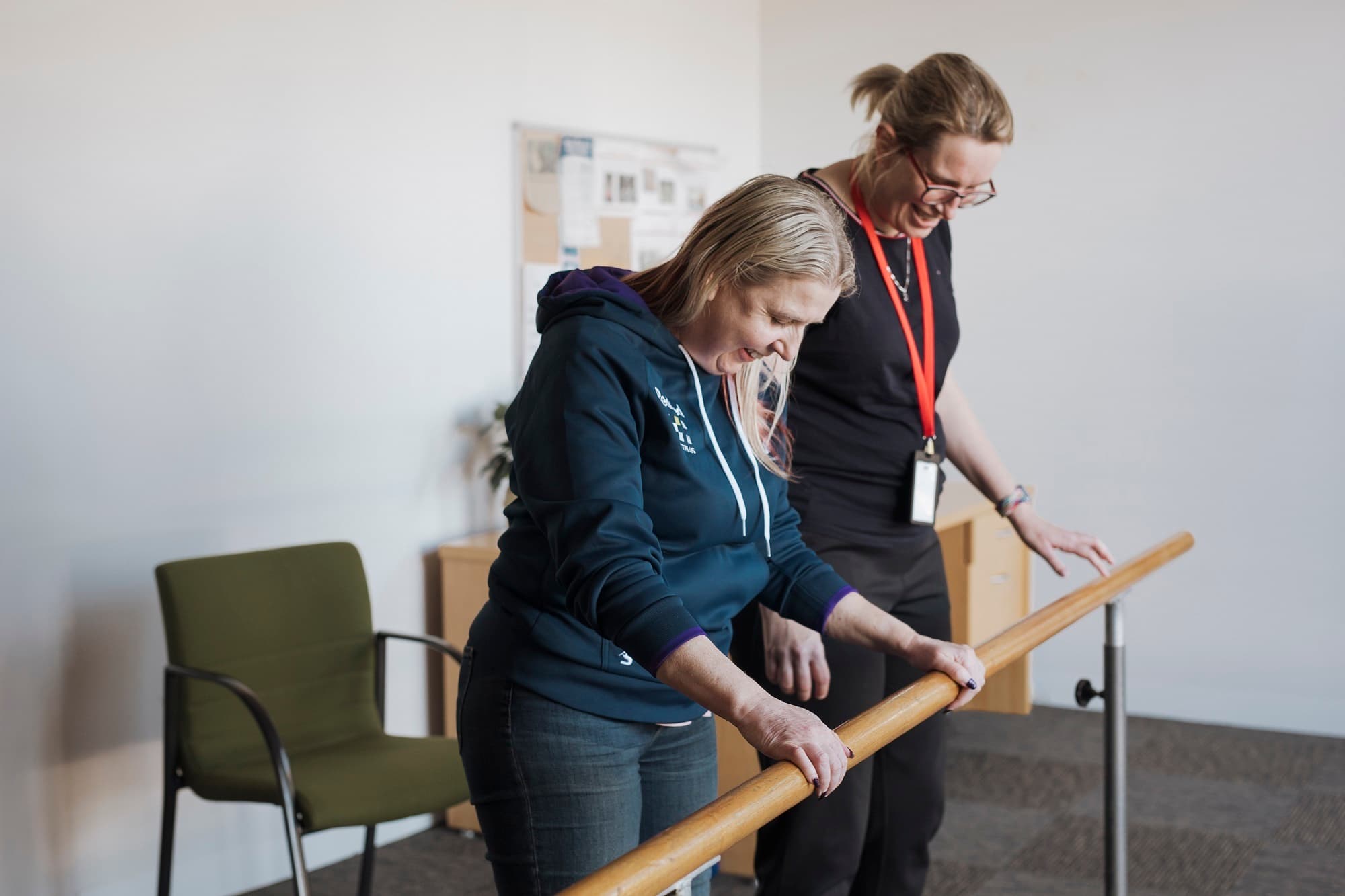 A client of MS Plus and an MS Plus Allied Health worker doing exercise using a support beam.