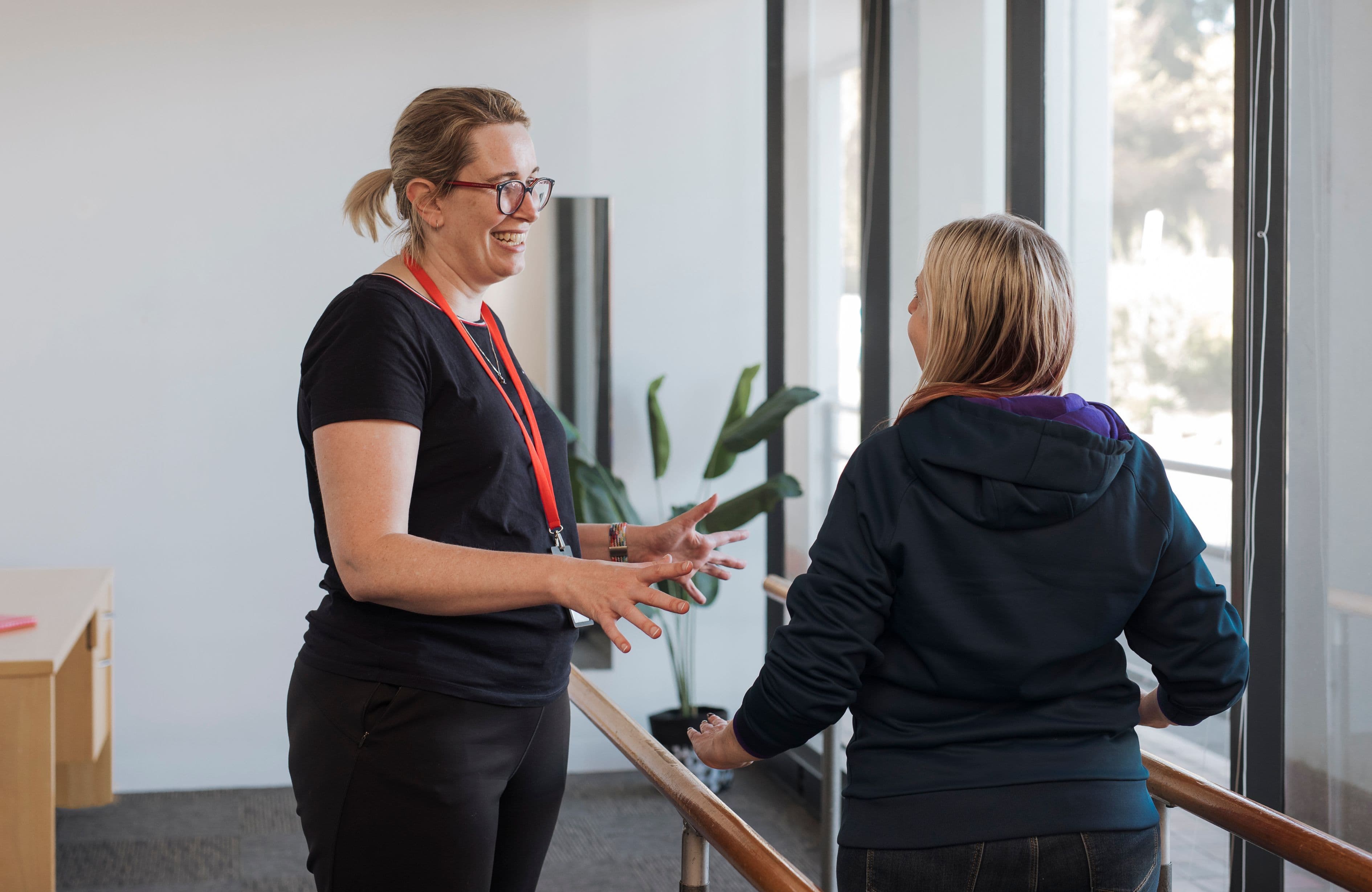 An MS Plus physiotherapist is instructing an MS Plus client in exercise.