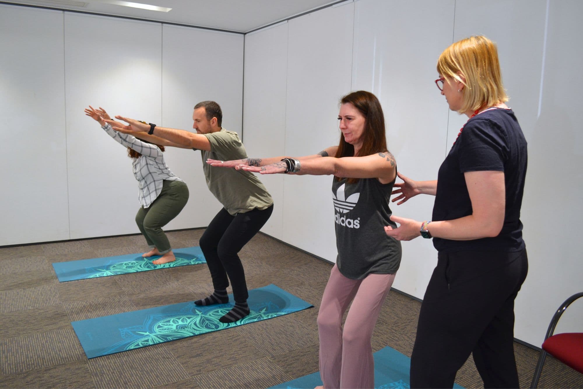 A neuro therapist providing Pilates instruction to three people.