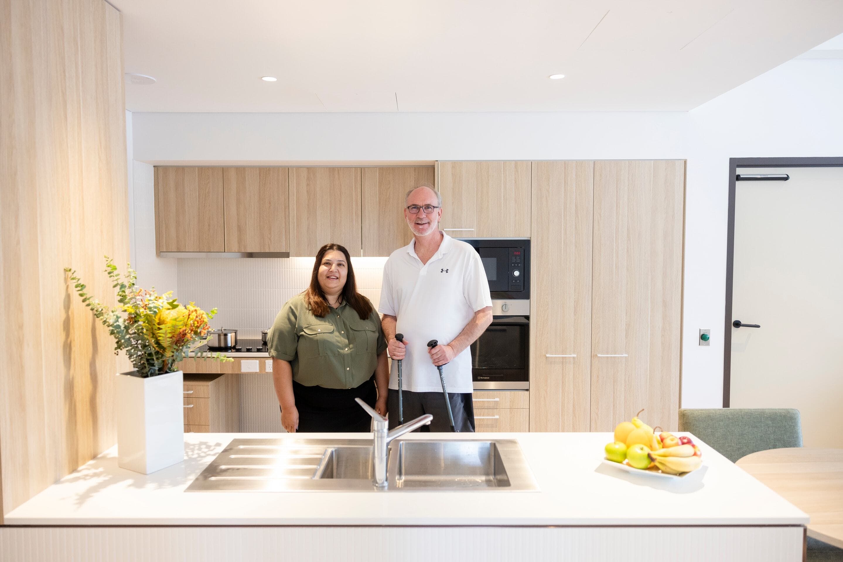 A man and a woman standing in the kitchen of an MS Plus supported accommodation location.