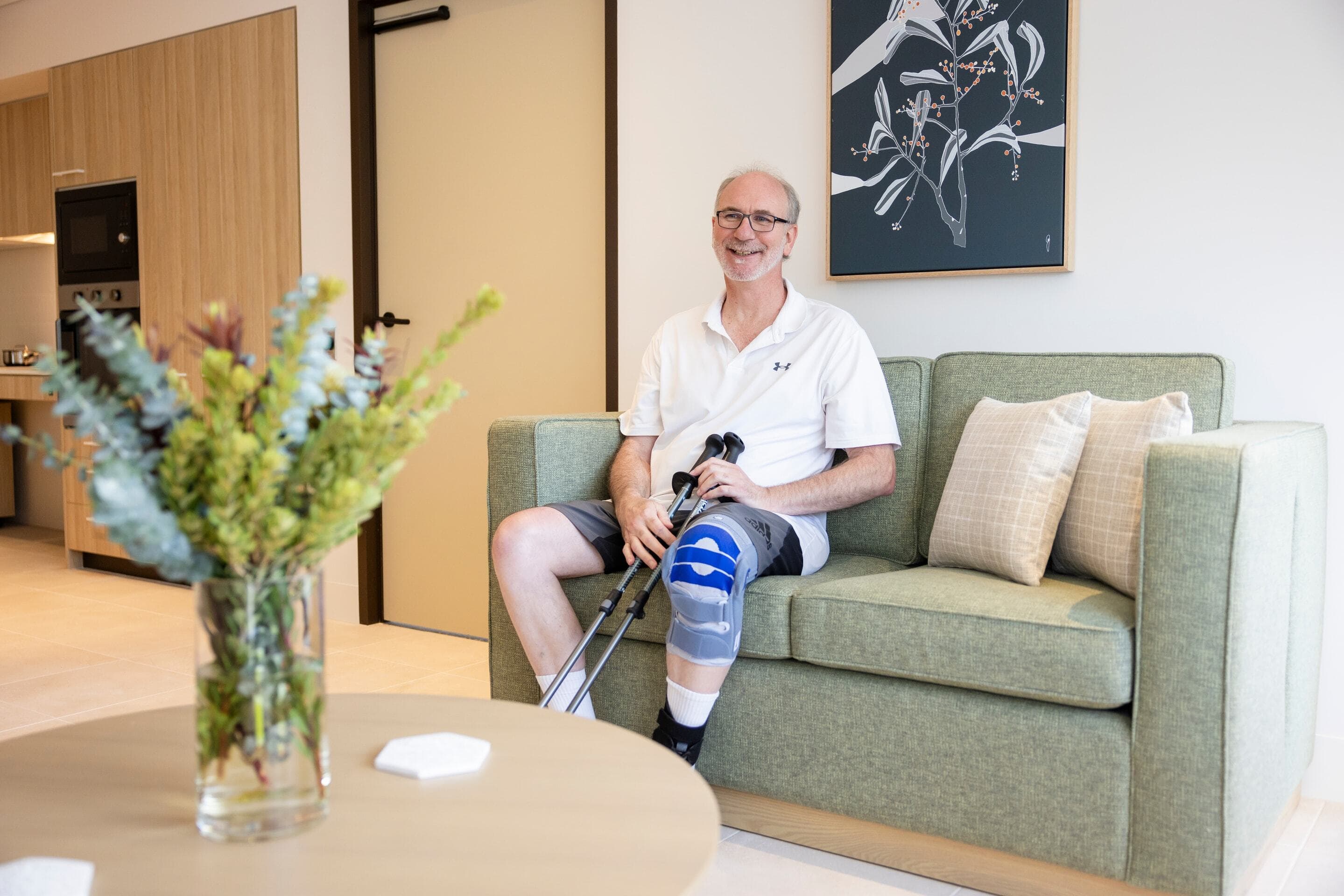 A person with crutches sitting on the couch.