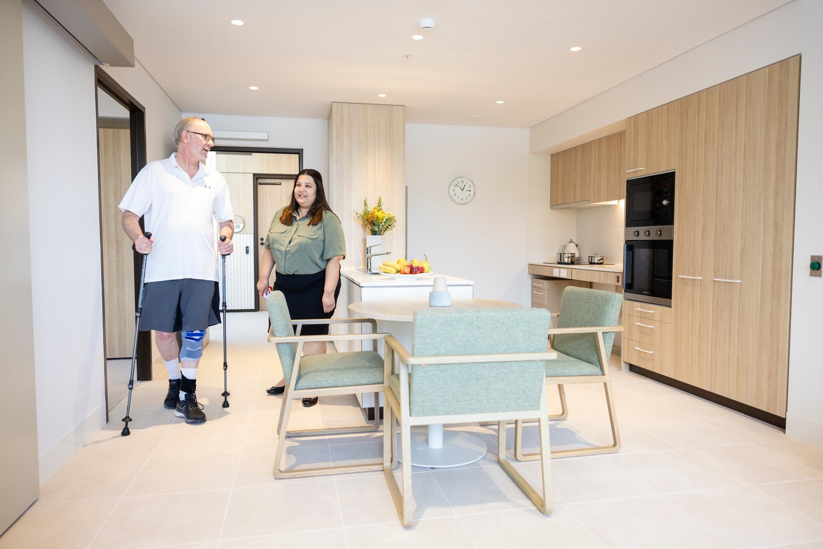 Two people inside a specialist disability accommodation apartment at Lidcombe Home