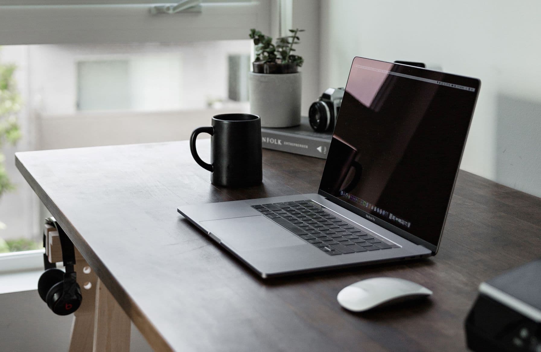 Laptop on wooden desk with coffee cup