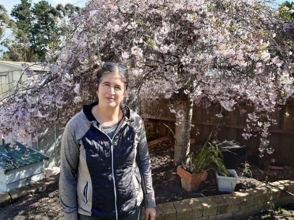Cheryl standing outside with blossoms