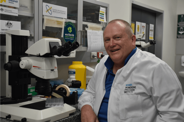 Dr hugh reid poses with lab equipment