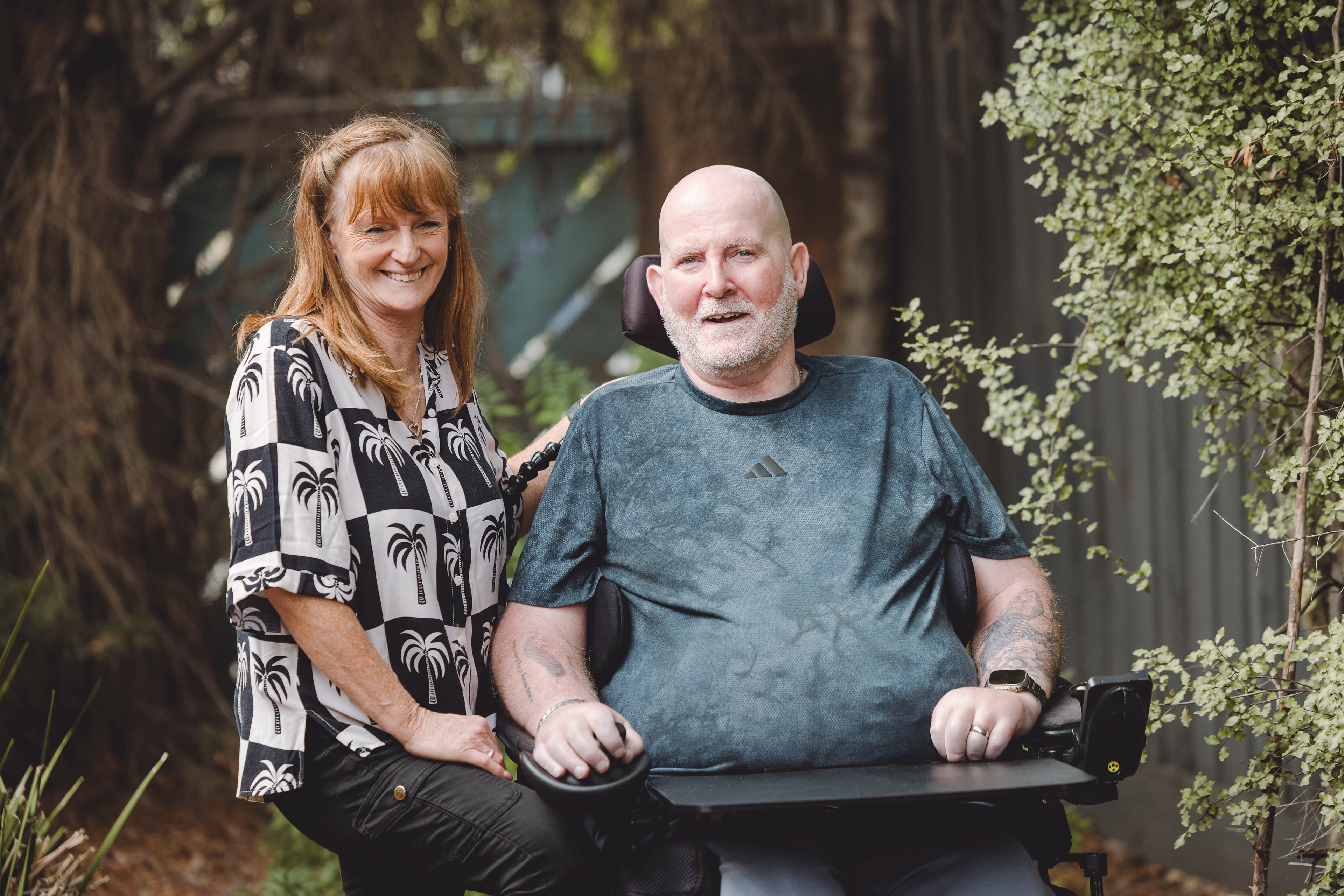 A support worker and a person living with multiple sclerosis in the garden of Watsonia Home.